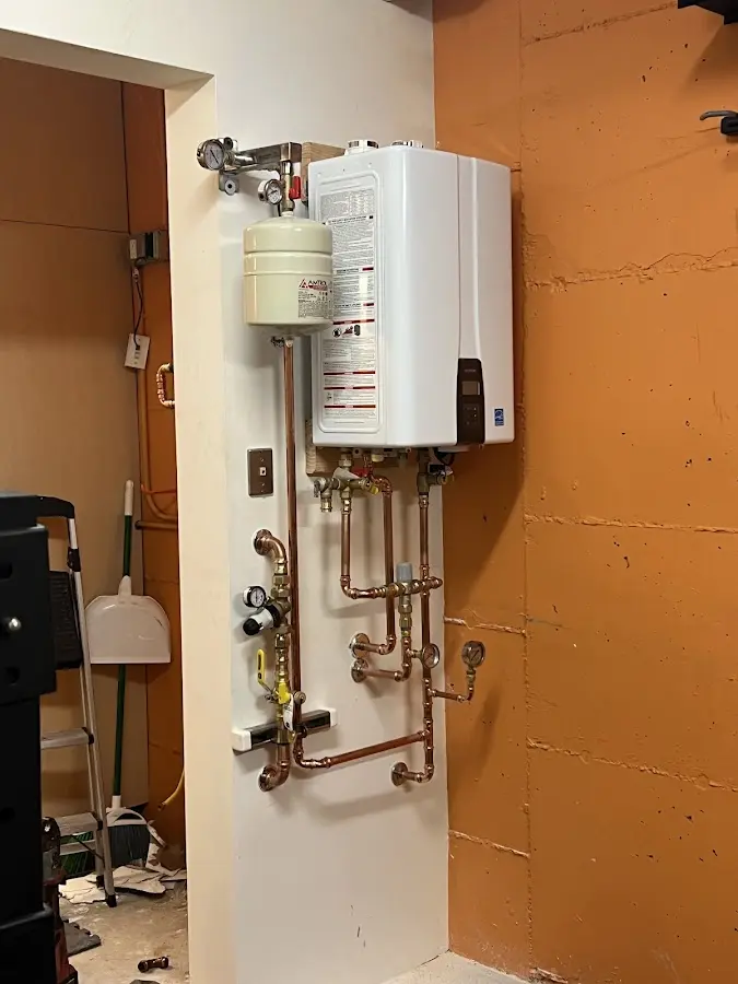 Plumbing technician inspecting water heater connections in Del City